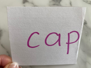index card with the word cap, e is folded out of view